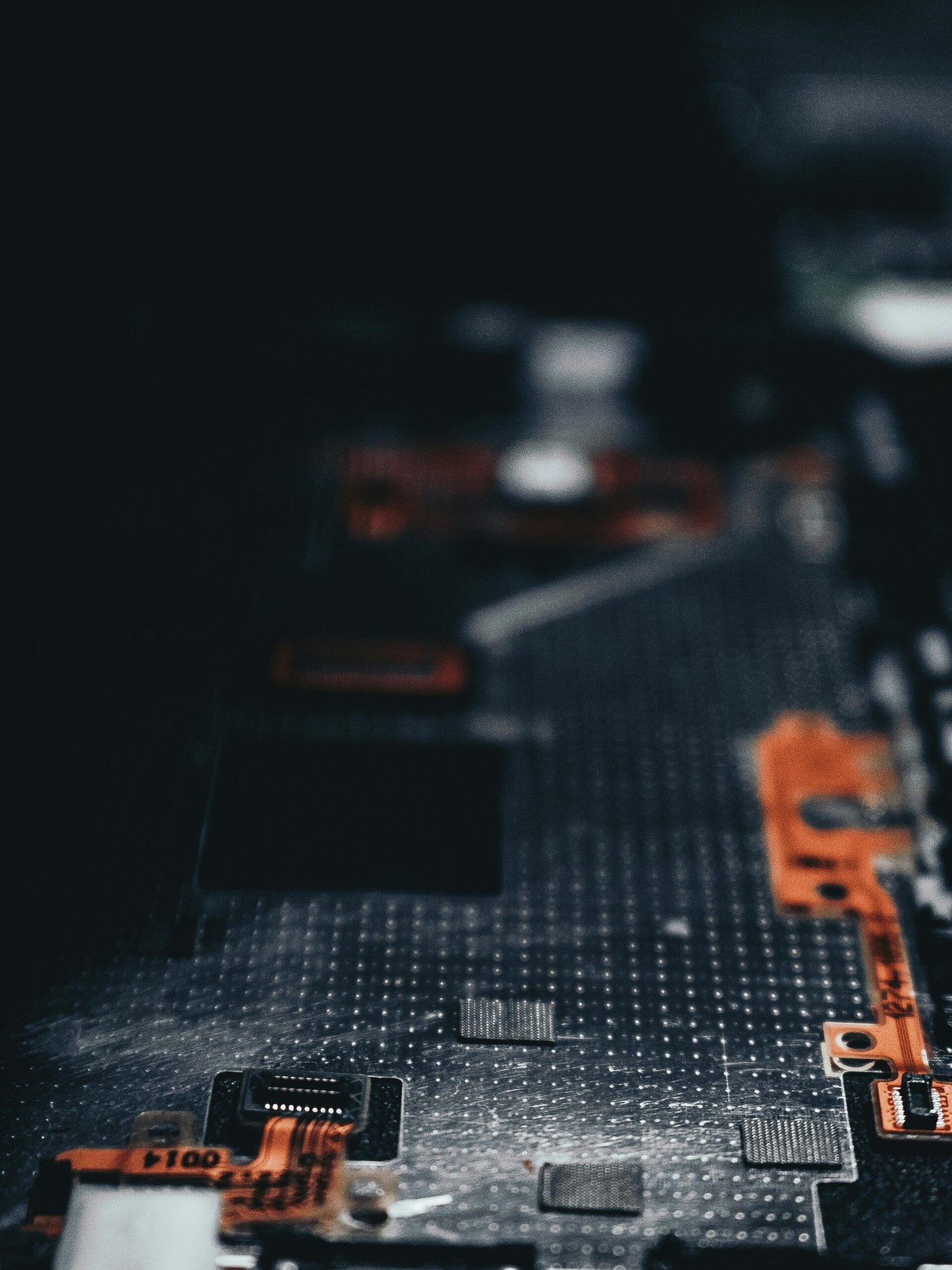 Close-up of a dark circuit board showcasing electronic components and connections.