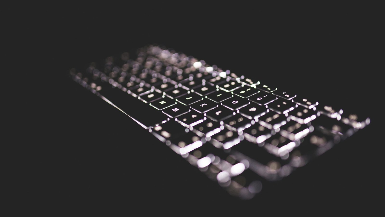 Close-up of a glowing keyboard with backlight on a dark background, emphasizing technology.
