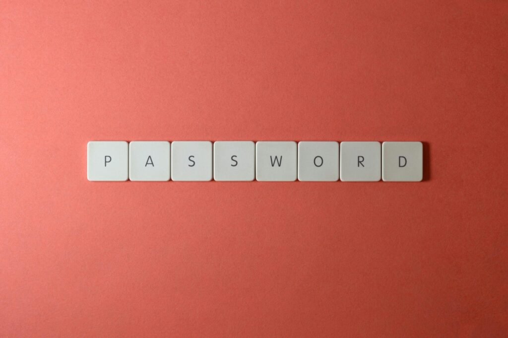 Focus on password security with white keyboard tiles spelling 'PASSWORD' on a coral background.