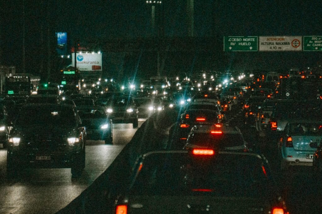 Dense nighttime traffic on a bustling city highway, showcasing bright headlights and taillights.