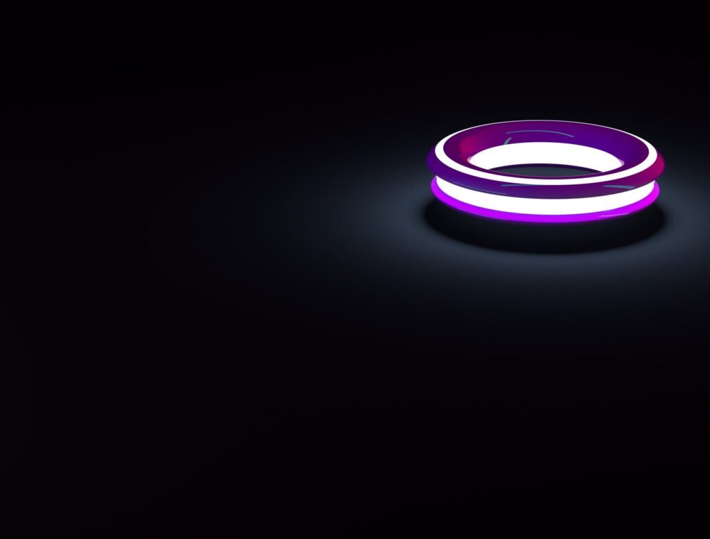 A luminous neon ring emits vibrant purple and white light in a dark setting.