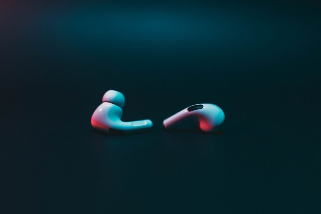 Close-up of wireless earphones on a moody dark backdrop. Ideal for tech themes.