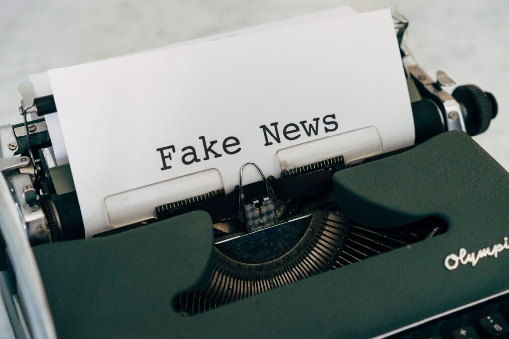 Close-up of vintage typewriter printing 'Fake News', depicting false information concepts.