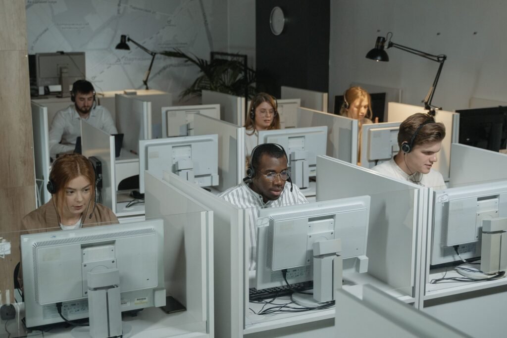 Professional customer support team working with headsets in a modern office environment.